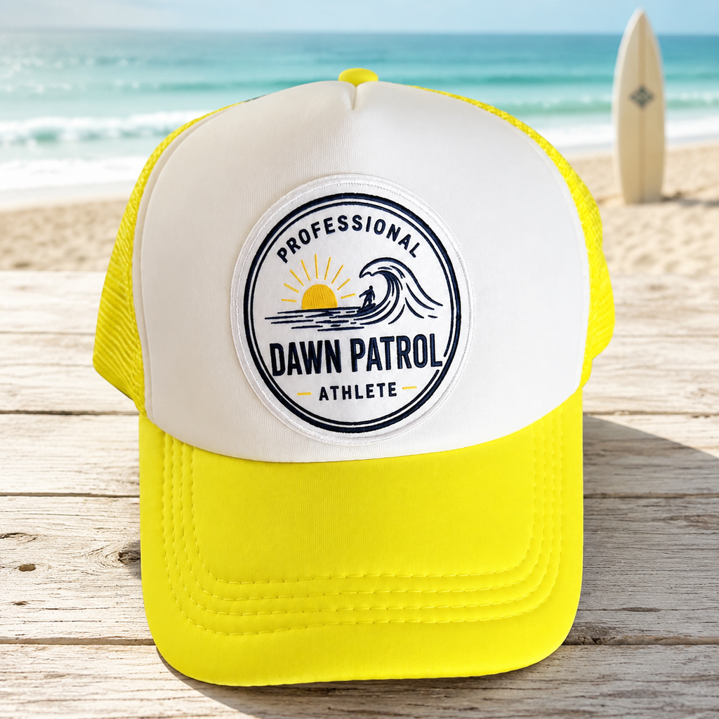 Professional Dawn Patrol Athlete yellow foam trucker hat on a beach

