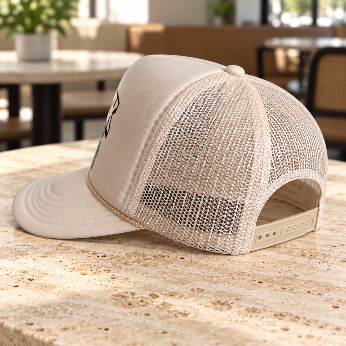 Rear view of cream mesh trucker hat with snapback closure