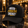 Main Character Energy black trucker hat with white and gold graphic